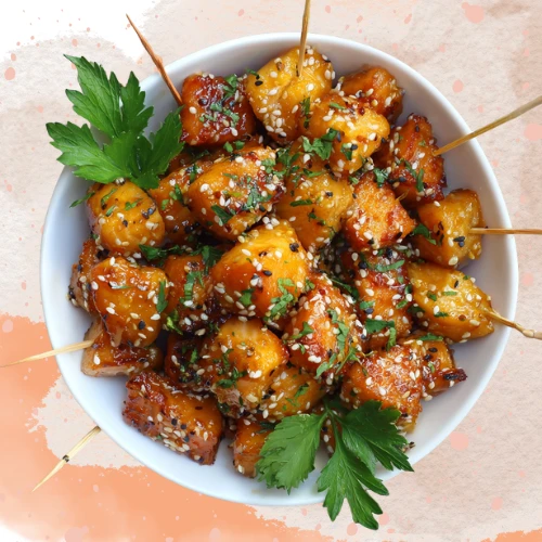 Bite-sized salmon cubes in bowl with glaze