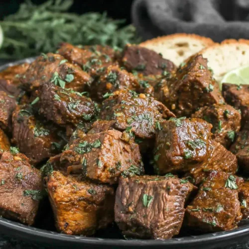 Tender steak bites cooked in crockpot with garlic butter and parsley.
