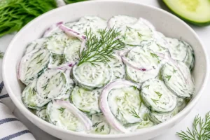 creamy cucumber salad with sour cream and fresh dill in a white bowl