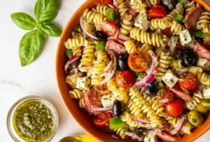 Easy Italian pasta salad with rotini, salami, mozzarella, olives, tomatoes, and Italian dressing