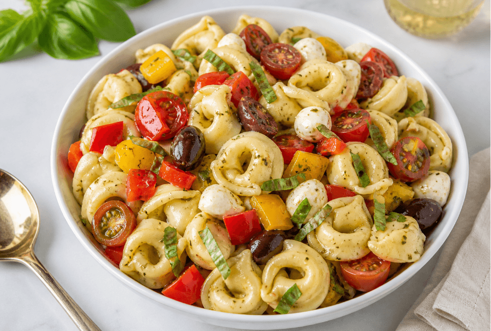 Cold tortellini pasta salad with olives, tomatoes, peppers, basil, and mozzarella