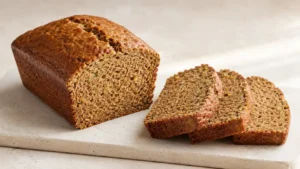 Sliced zucchini bread loaf with a tender cinnamon crumb and fine green zucchini flecks