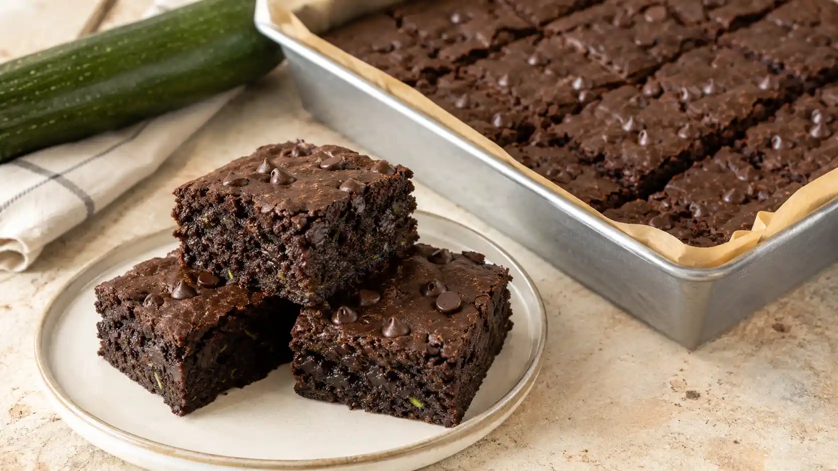Chocolate zucchini brownies cut into squares with melted chocolate chips and a moist fully baked center
