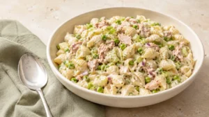 Creamy tuna pasta salad with shell pasta, tuna, peas, celery, red onion, and dill